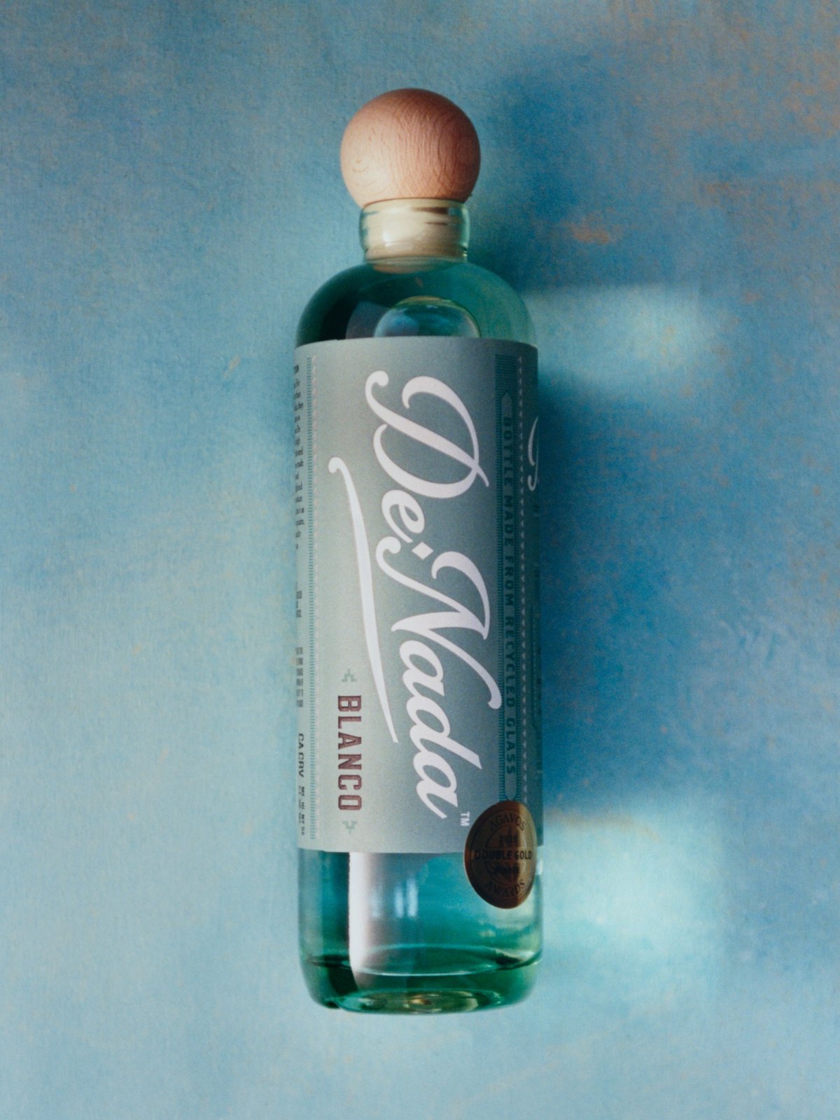 The Blanco lying on a painted blue wall, the Double Gold medal on the label